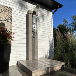 Douche extérieure, poteau et sol carrelé en gris clair
